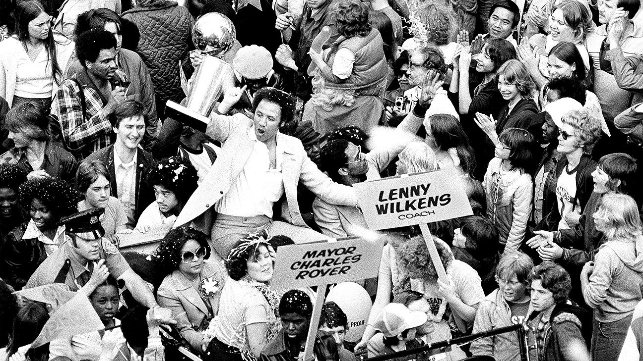 Lenny Wilkens holds up the NBA championship trophy surrounded by some of the thousands of fans who lined Seattle streets on June 4, 1979, in celebration of the Sonics' victory over the Washington Bullets.
