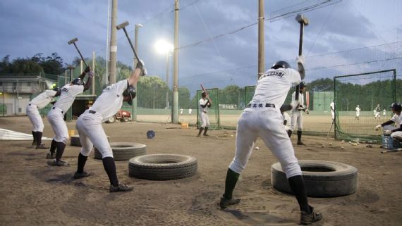 Baseball players exercising with sledgehammers and tires