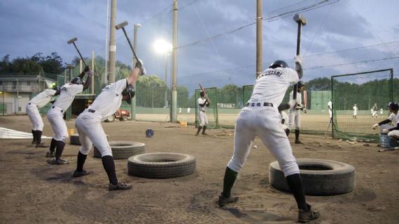 Baseball players exercising with sledgehammers and tires