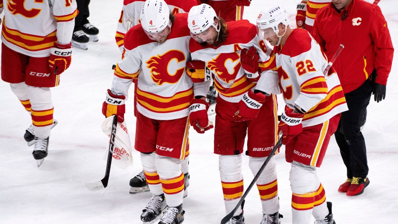 Flames' Tanev helped off after slap shot to head